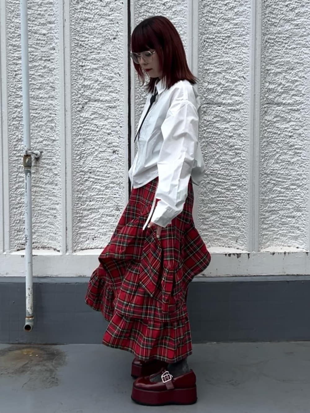 レッド系のスカート、レッド系のローファー、ホワイト系のシャツ/ブラウスを着用したレディースの夏コーディネートの2枚目の写真