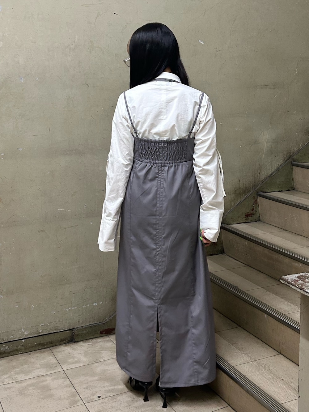 グレー系のワンピース、ホワイト系のシャツ/ブラウス、ブラック系のパンプスを着用したレディースの冬コーディネートの3枚目の写真