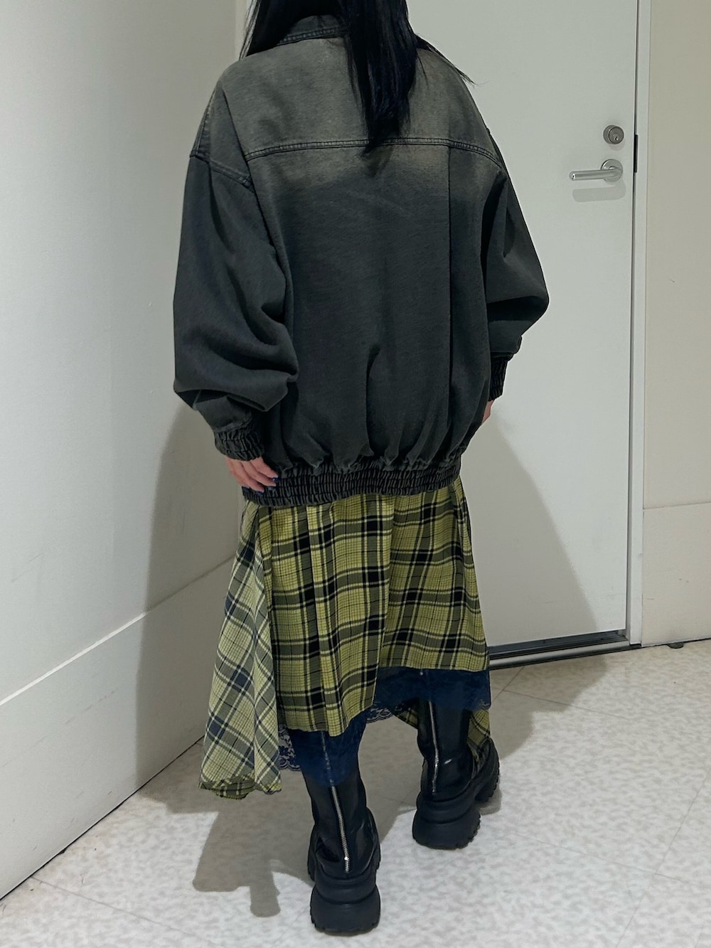 ブラック系のデニムジャケット、イエロー系のスカート、ブラック系のブーツを着用したレディースの春コーディネートの3枚目の写真