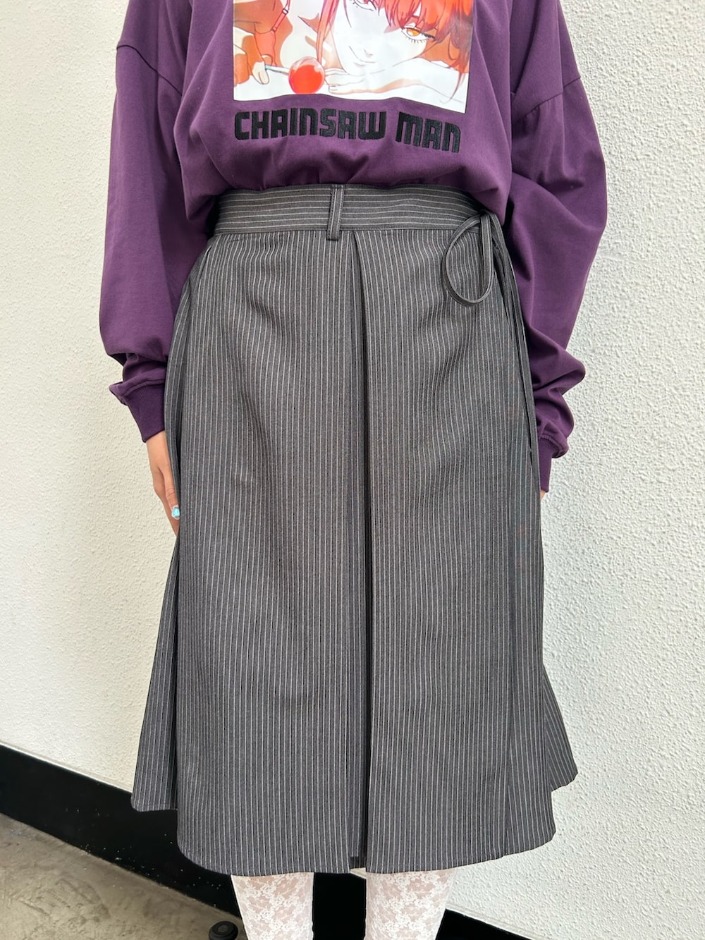 グレー系のスカート、ブラック系のドレスシューズ、パープル系のTシャツ/カットソーを着用したレディースの夏コーディネートの6枚目の写真