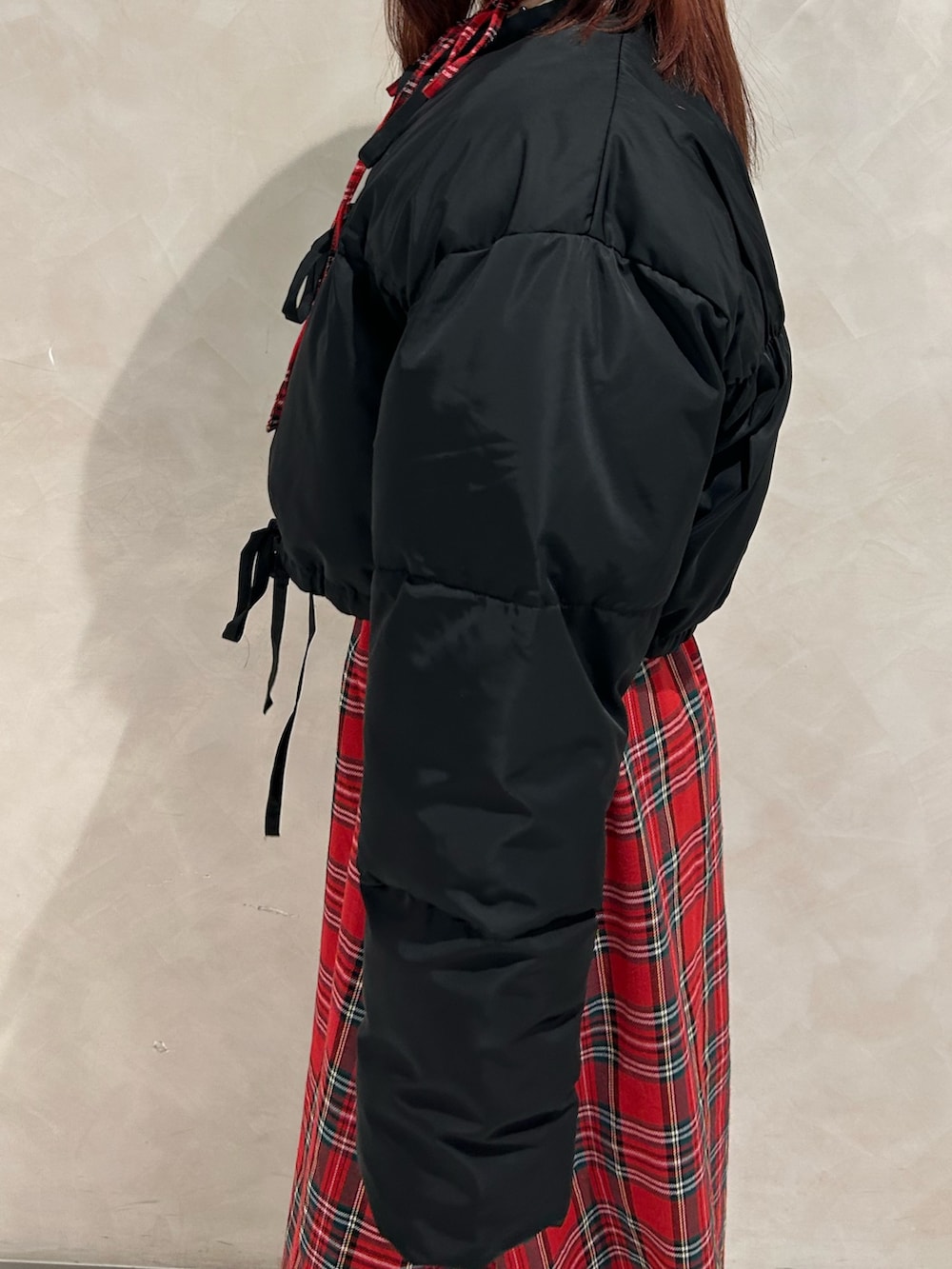 レッド系のワンピース、ブラック系のブルゾン、ブラック系のドレスシューズを着用したレディースの冬コーディネートの5枚目の写真