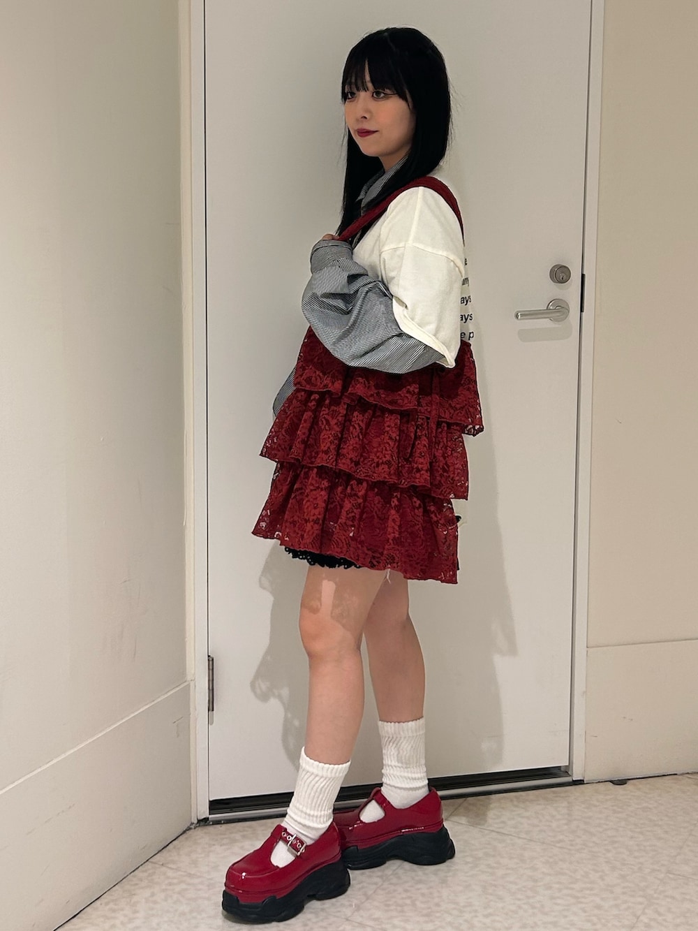 ホワイト系のTシャツ/カットソー、レッド系のスニーカー、レッド系のトートバッグを着用したレディースの春コーディネートの2枚目の写真