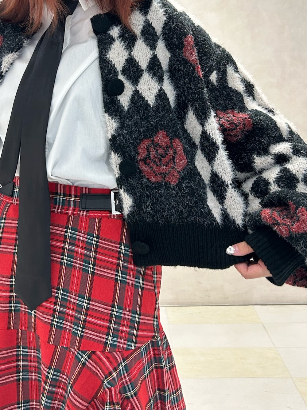 レッド系のスカート、ブラック系のドレスシューズ、ブラック系のカーディガン/ボレロを着用したレディースの秋コーディネートの4枚目の写真