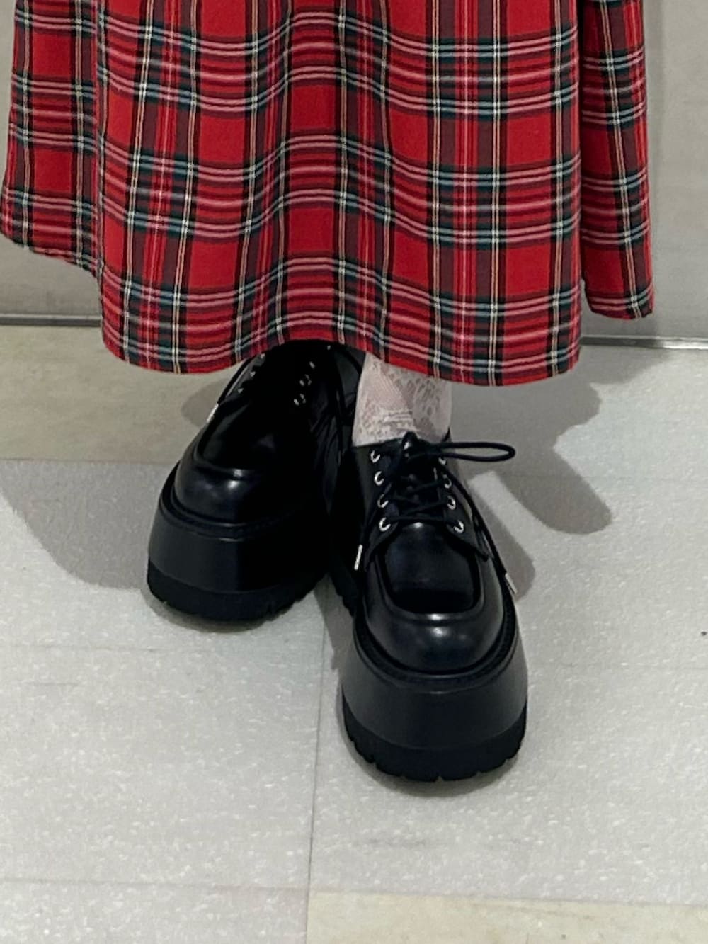 レッド系のワンピース、ブラック系のブルゾン、ブラック系のドレスシューズを着用したレディースの冬コーディネートの7枚目の写真