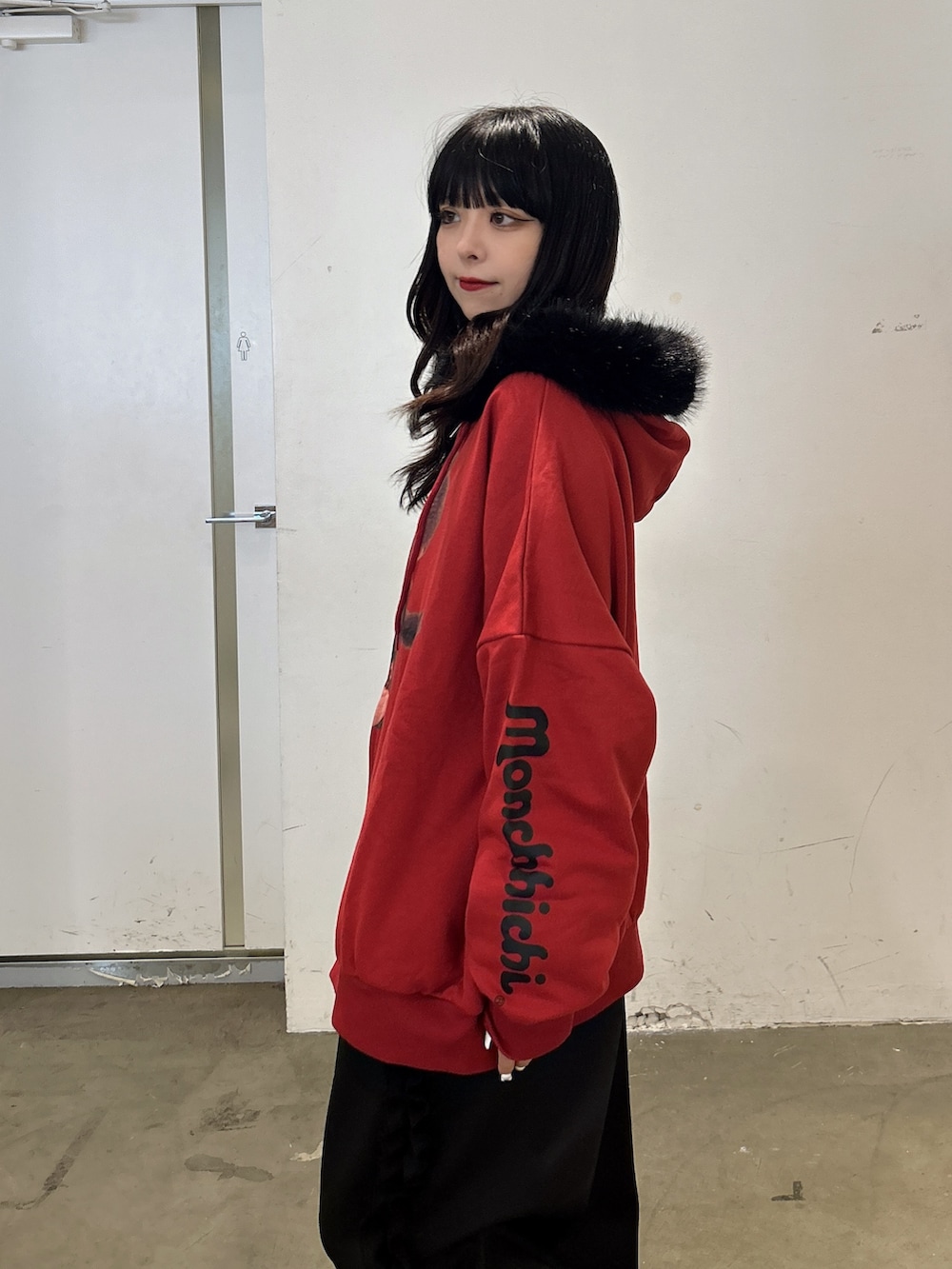 レッド系のパーカー、ブラック系のその他パンツ、ブラック系のブーツを着用したレディースの秋コーディネートの4枚目の写真