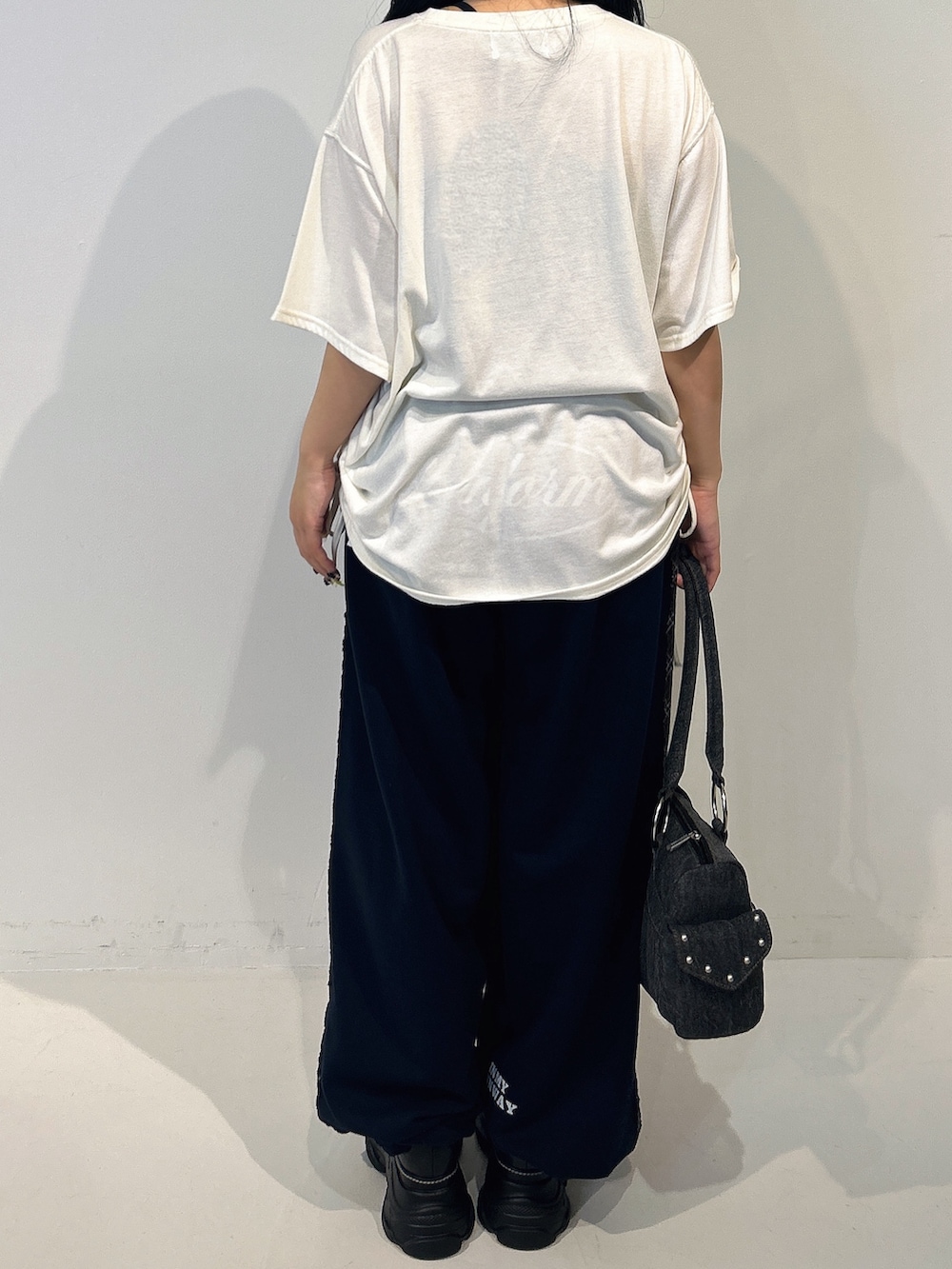 ブルー系のその他パンツ、ホワイト系のTシャツ/カットソー、ブラック系のボストンバッグを着用したレディースの春コーディネートの3枚目の写真