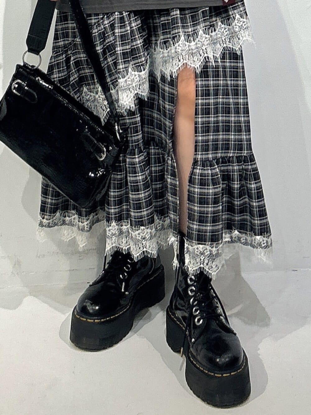 ブラック系のハンドバッグ、ブラック系のブーツ、グレー系のワンピースを着用したレディースの冬コーディネートの5枚目の写真