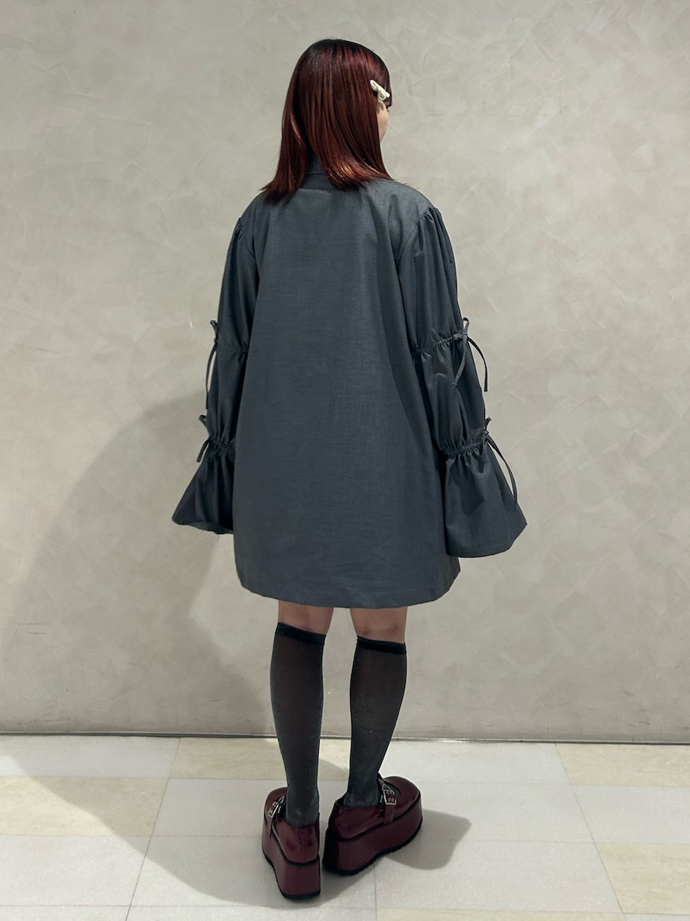 グレー系のワンピース、レッド系のドレスシューズ、ホワイト系のTシャツ/カットソーを着用したレディースの秋コーディネートの3枚目の写真