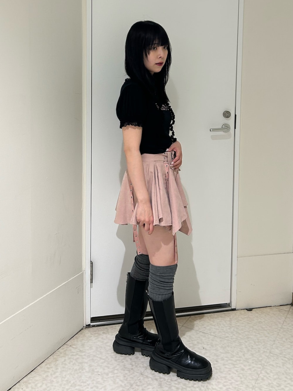 ブラック系のTシャツ/カットソー、ピンク系のスカート、ブラック系のブーツを着用したレディースの春コーディネートの2枚目の写真