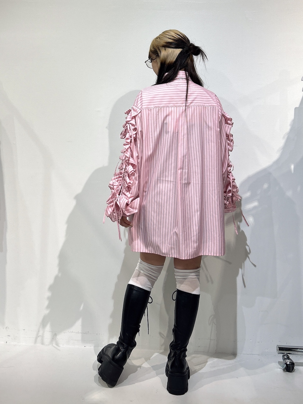 ピンク系のシャツ/ブラウス、ブラック系のブーツを着用したレディースの冬コーディネートの3枚目の写真