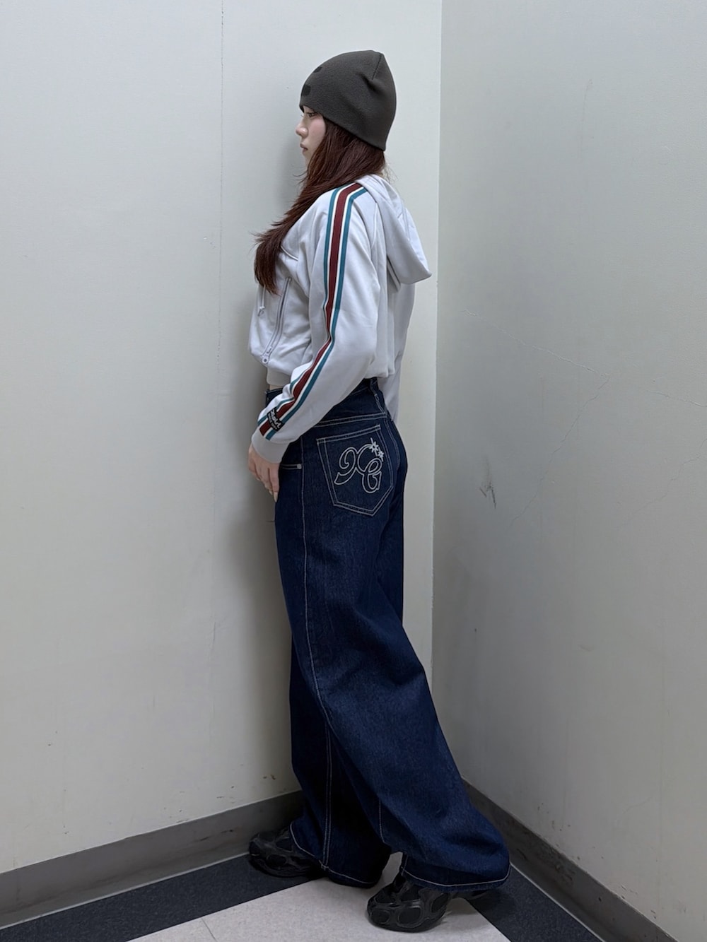 グレー系のパーカー、ブルー系のデニムパンツ、グリーン系のニットキャップ/ビーニーを着用したレディースの秋コーディネートの2枚目の写真