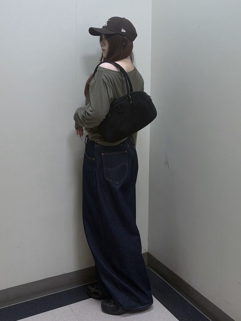 グリーン系のTシャツ/カットソー、ブルー系のデニムパンツ、ブラック系のハンドバッグを着用したレディースの夏コーディネートの2枚目の写真