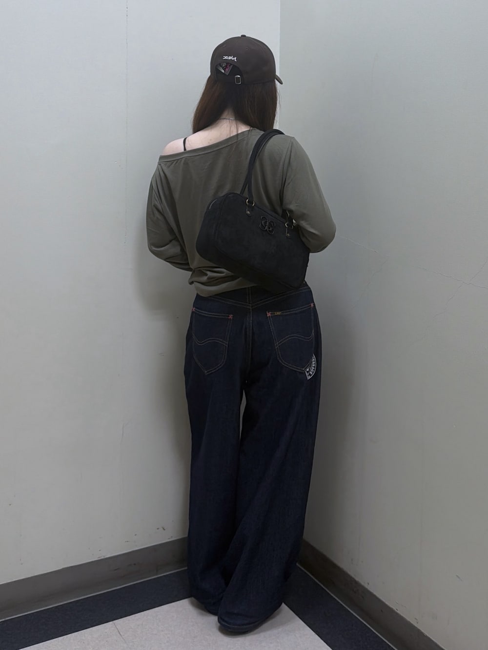 グリーン系のTシャツ/カットソー、ブルー系のデニムパンツ、ブラック系のハンドバッグを着用したレディースの夏コーディネートの3枚目の写真