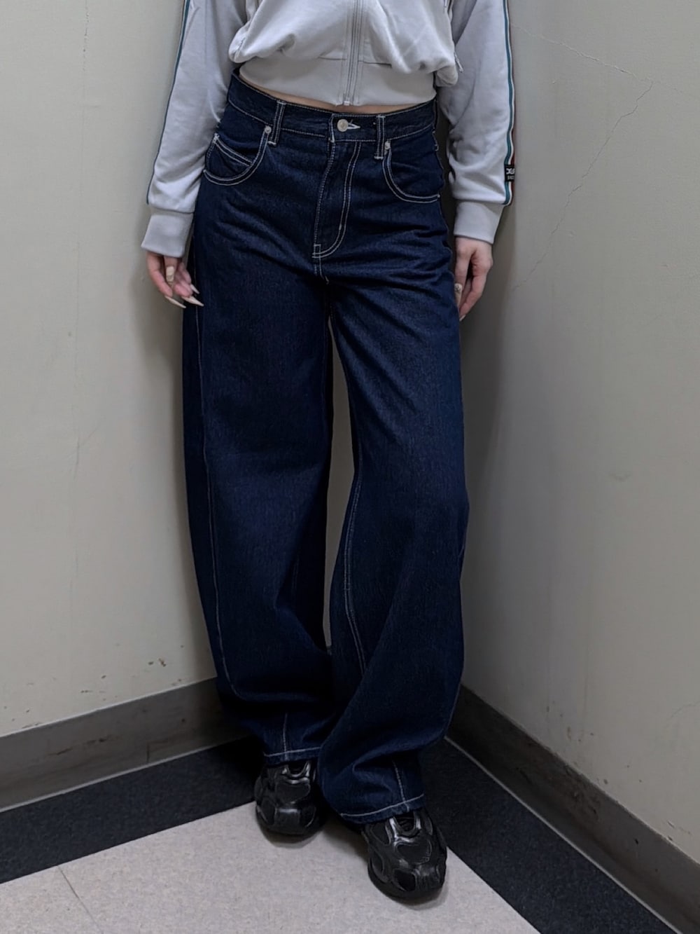 グレー系のパーカー、ブルー系のデニムパンツ、グリーン系のニットキャップ/ビーニーを着用したレディースの秋コーディネートの5枚目の写真