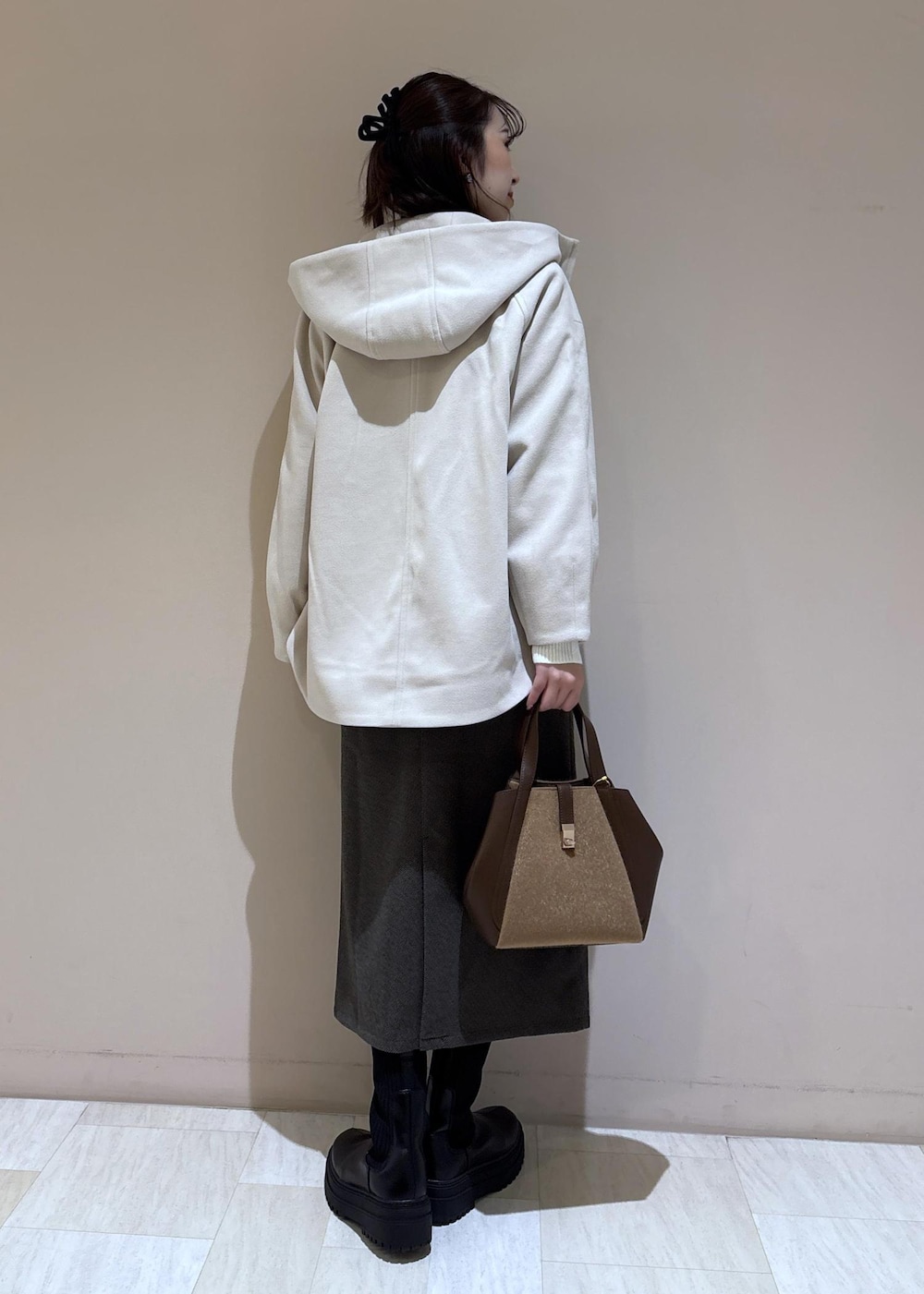 ホワイト系のニット/セーター、ホワイト系のシャツ/ブラウス、ブラウン系のトートバッグを着用したレディースの秋コーディネートの3枚目の写真