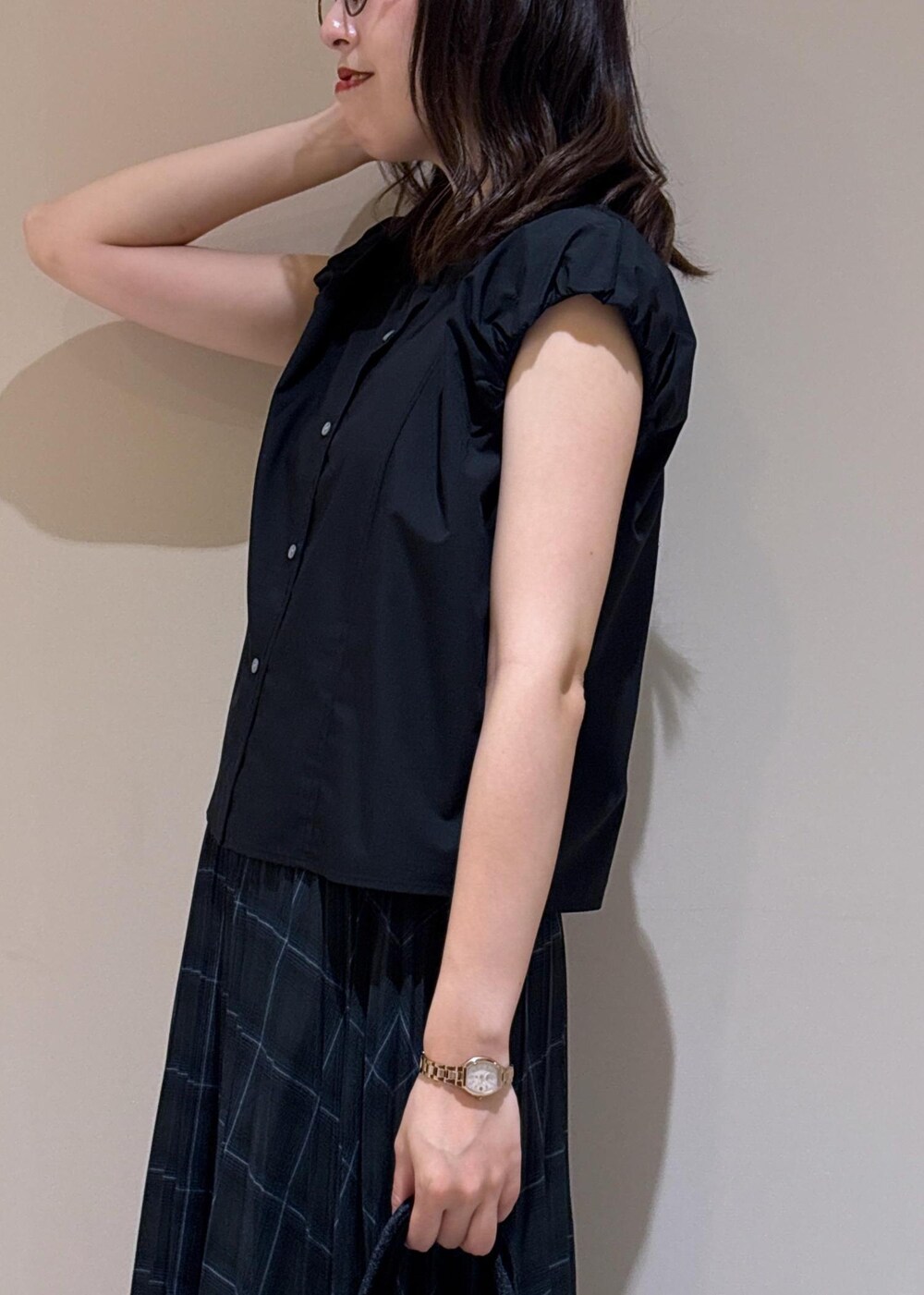 グリーン系のスカート、ブラック系のシャツ/ブラウス、シルバー系のローファーを着用したレディースの夏コーディネートの6枚目の写真