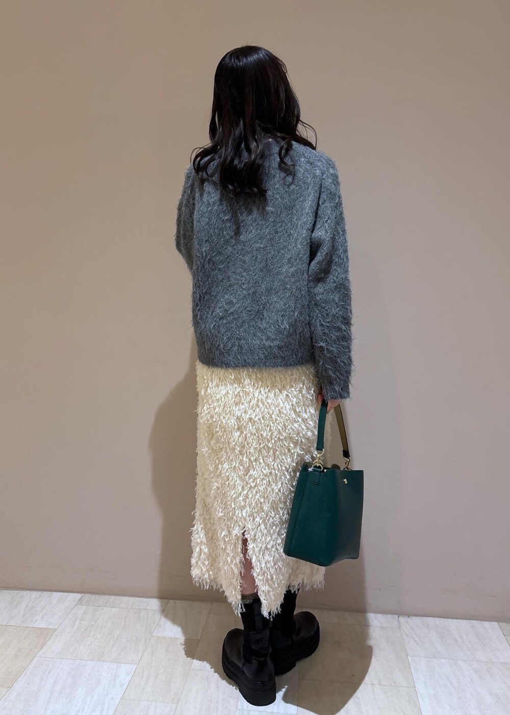 ホワイト系のスカート、グレー系のニット/セーターを着用したレディースの冬コーディネートの4枚目の写真