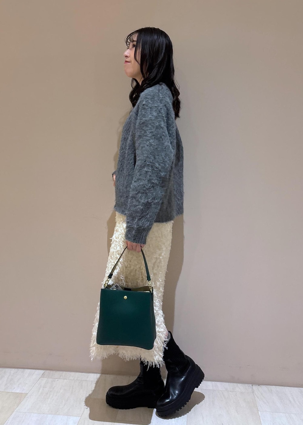 ホワイト系のスカート、グレー系のニット/セーターを着用したレディースの冬コーディネートの3枚目の写真