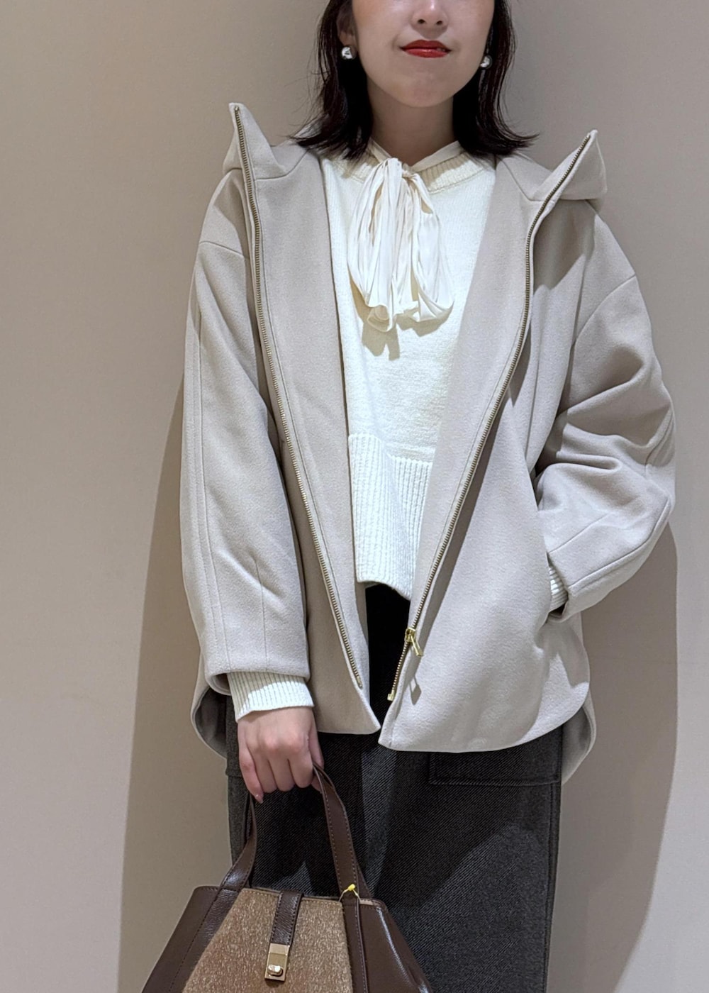 ホワイト系のニット/セーター、ホワイト系のシャツ/ブラウス、ブラウン系のトートバッグを着用したレディースの秋コーディネートの8枚目の写真