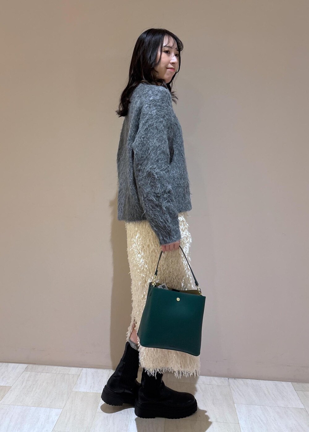 ホワイト系のスカート、グレー系のニット/セーターを着用したレディースの冬コーディネートの5枚目の写真