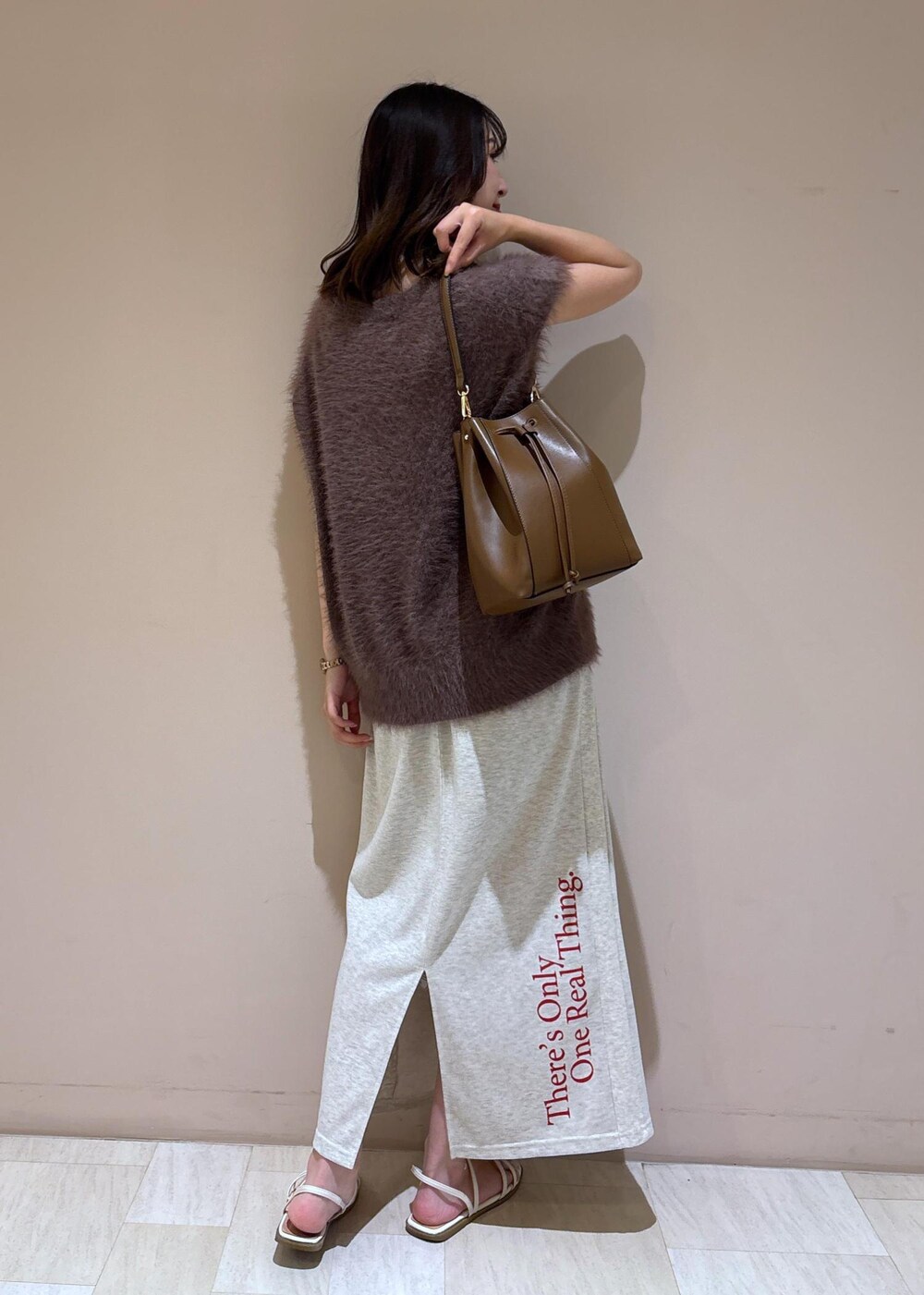 ブラウン系のショルダーバッグ、ブラウン系のベスト、グレー系のスカートを着用したレディースの夏コーディネートの9枚目の写真