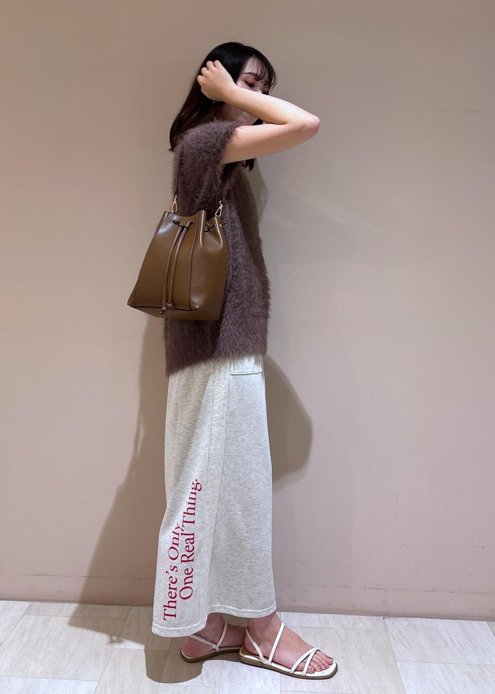 ブラウン系のショルダーバッグ、ブラウン系のベスト、グレー系のスカートを着用したレディースの夏コーディネートの10枚目の写真
