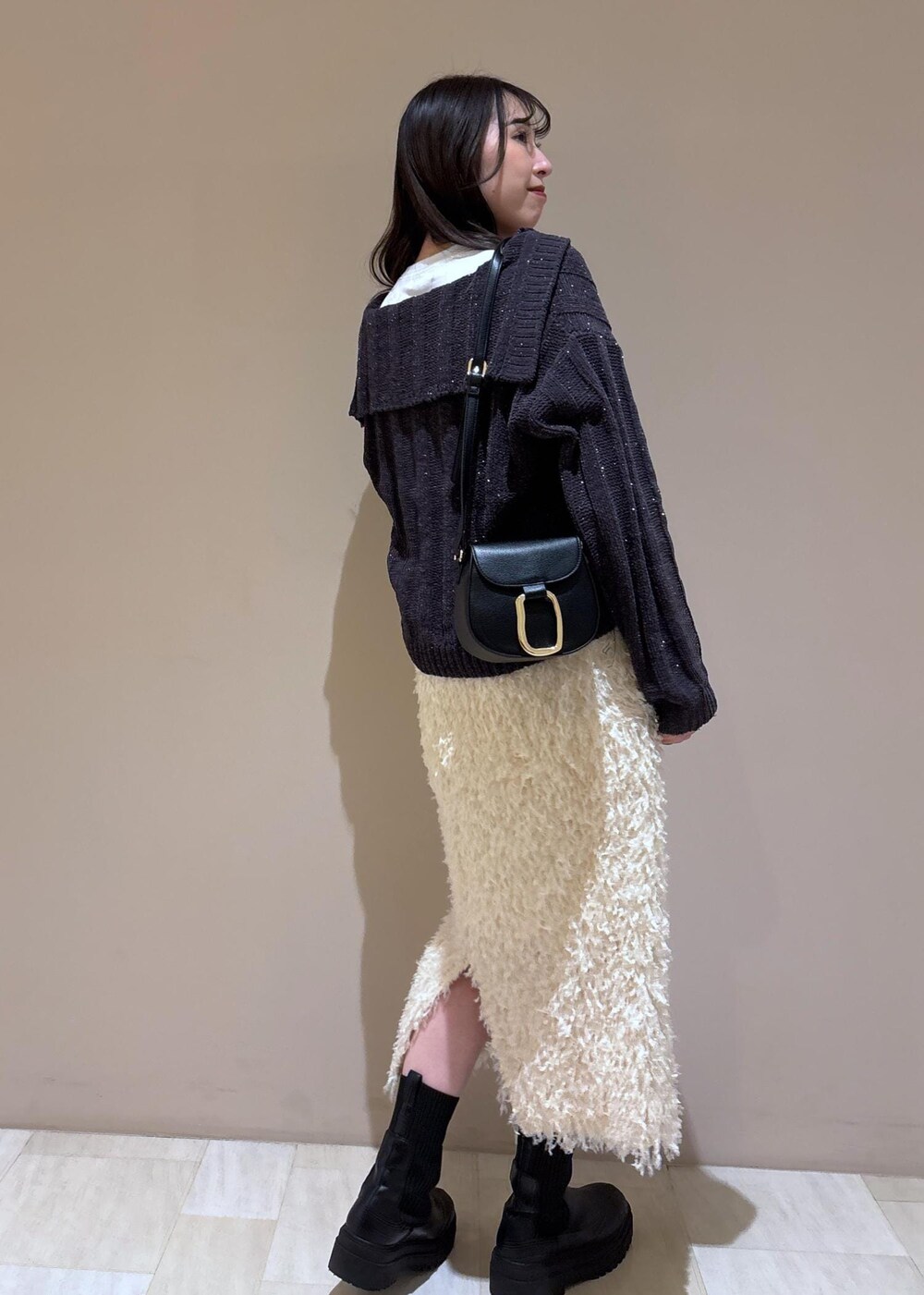 ホワイト系のスカート、ホワイト系のTシャツ/カットソー、グレー系のニット/セーターを着用したレディースの冬コーディネートの5枚目の写真