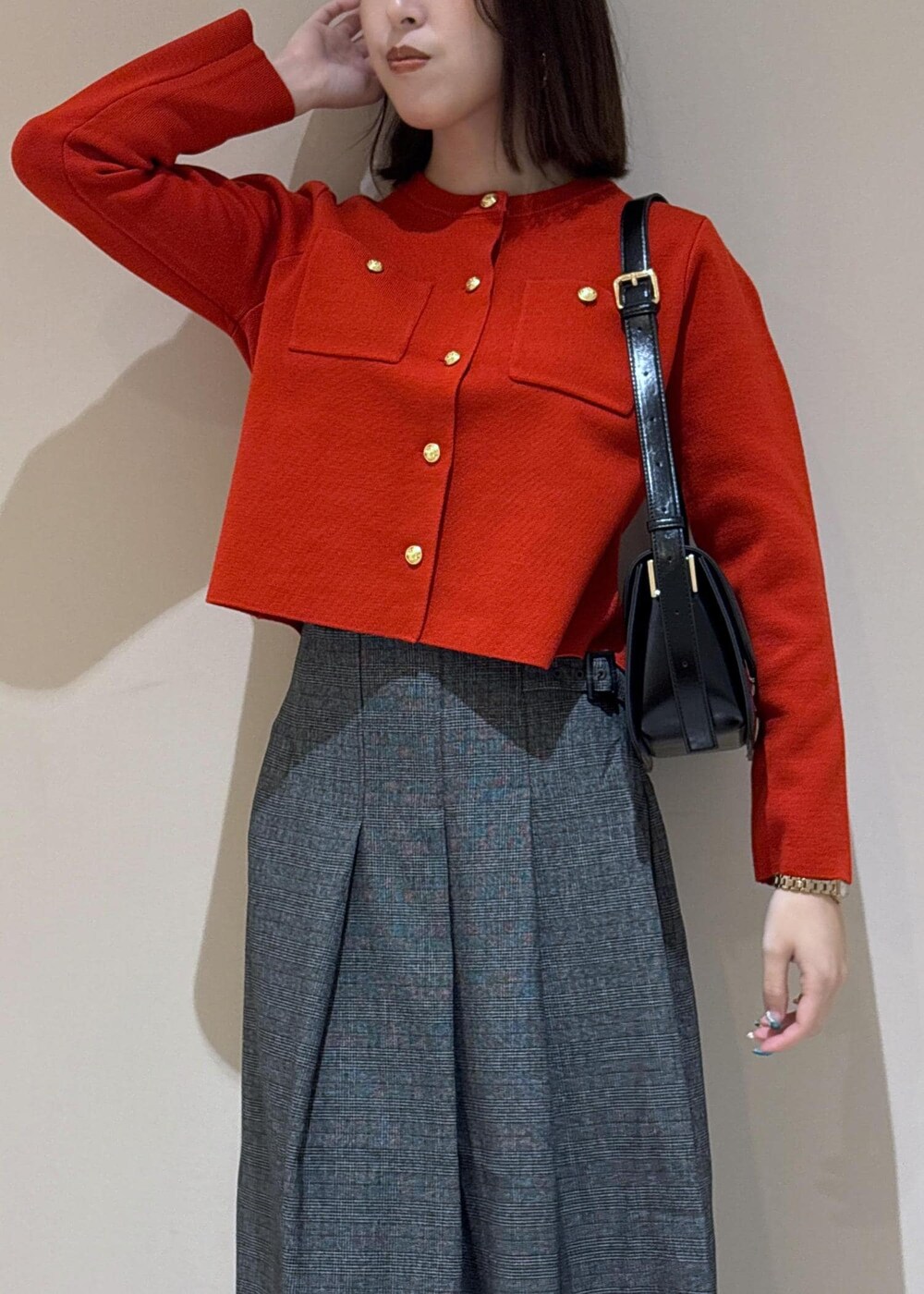 ブラック系のショルダーバッグ、グレー系のスカート、ブラック系のパンプスを着用したレディースの秋コーディネートの5枚目の写真