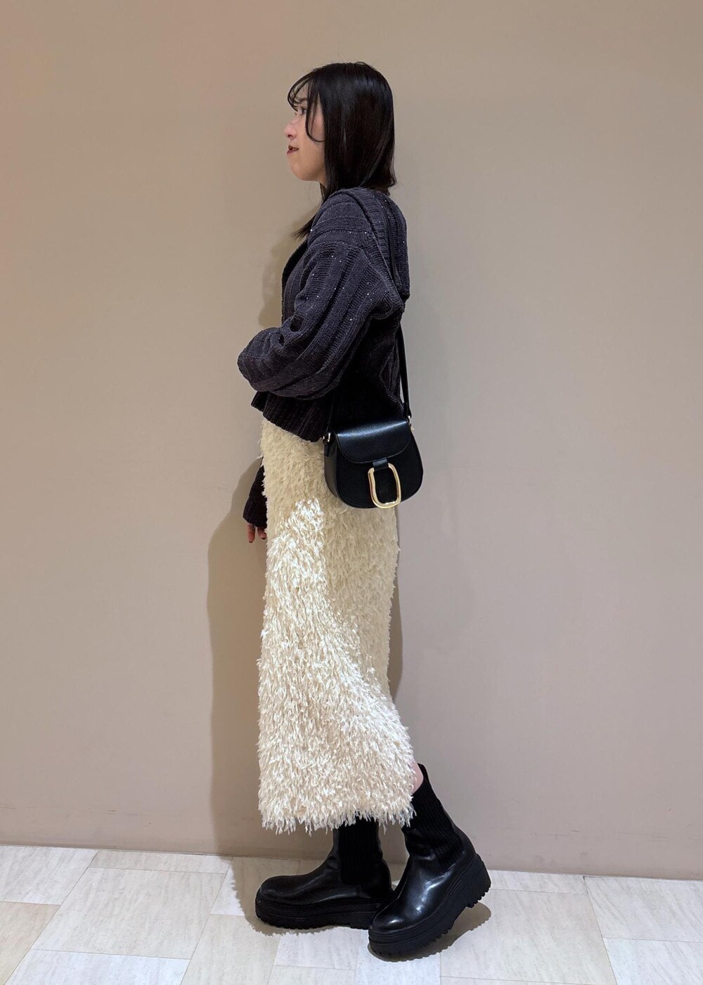 ホワイト系のスカート、ホワイト系のTシャツ/カットソー、グレー系のニット/セーターを着用したレディースの冬コーディネートの3枚目の写真