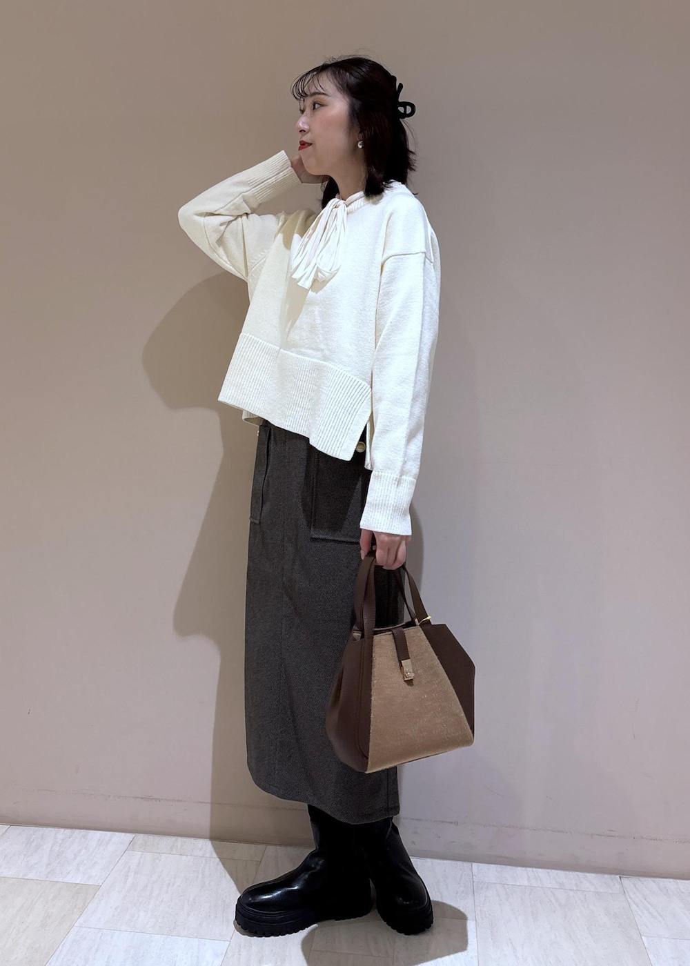 ホワイト系のニット/セーター、ホワイト系のシャツ/ブラウス、ブラウン系のトートバッグを着用したレディースの秋コーディネートの5枚目の写真