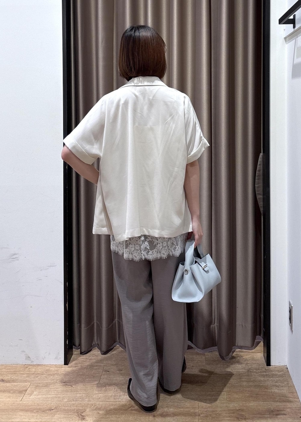 グレー系のその他パンツ、ブルー系のショルダーバッグ、ホワイト系のテーラードジャケットを着用したレディースの春コーディネートの10枚目の写真