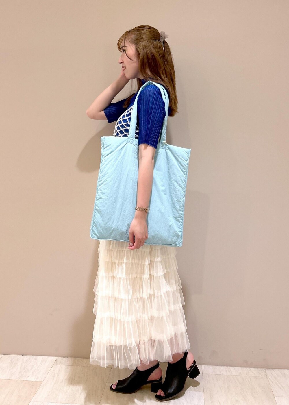 ブルー系のトートバッグ、ブラック系のサンダル、ブルー系のTシャツ/カットソーを着用したレディースの夏コーディネートの2枚目の写真