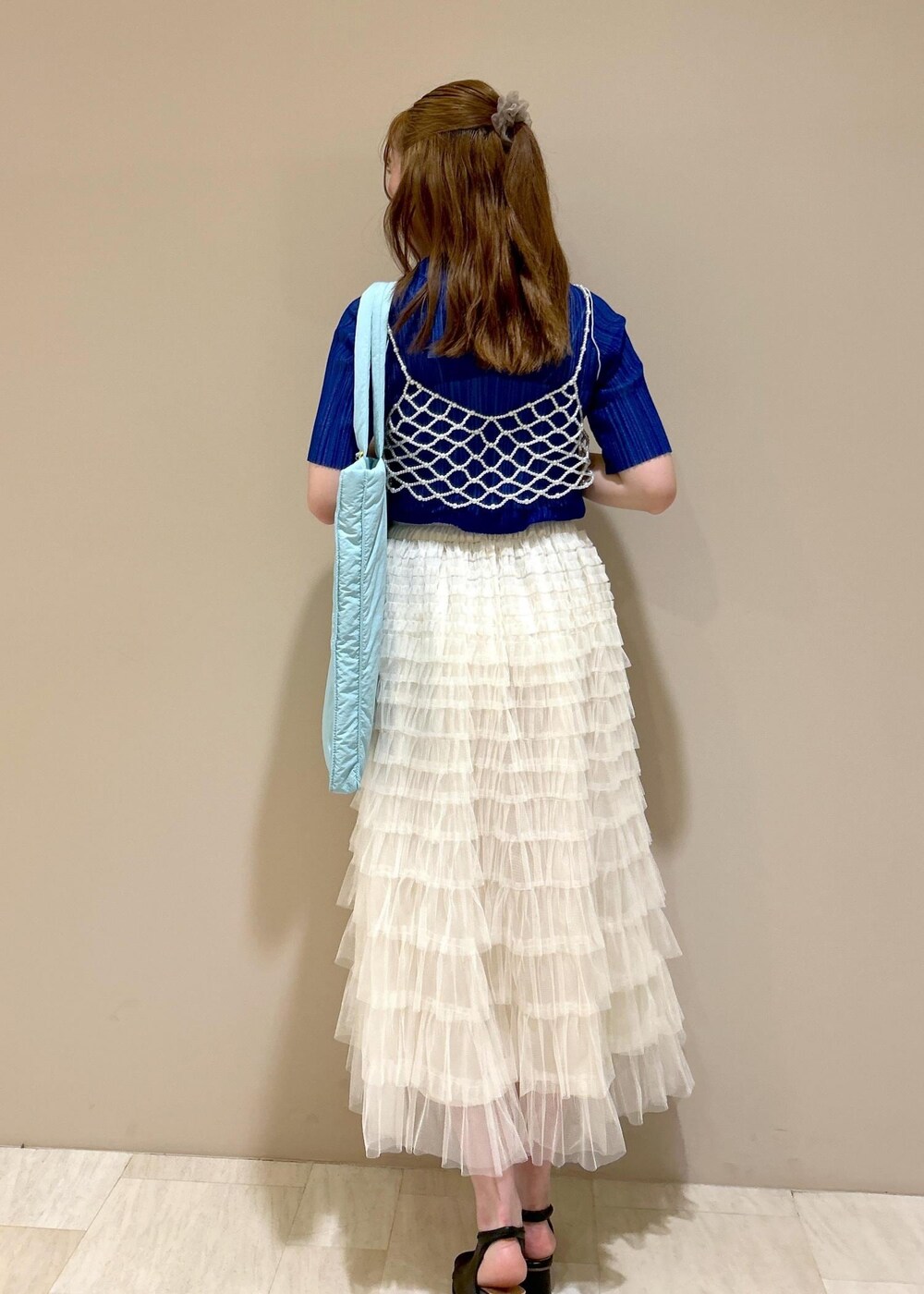 ブルー系のトートバッグ、ブラック系のサンダル、ブルー系のTシャツ/カットソーを着用したレディースの夏コーディネートの3枚目の写真