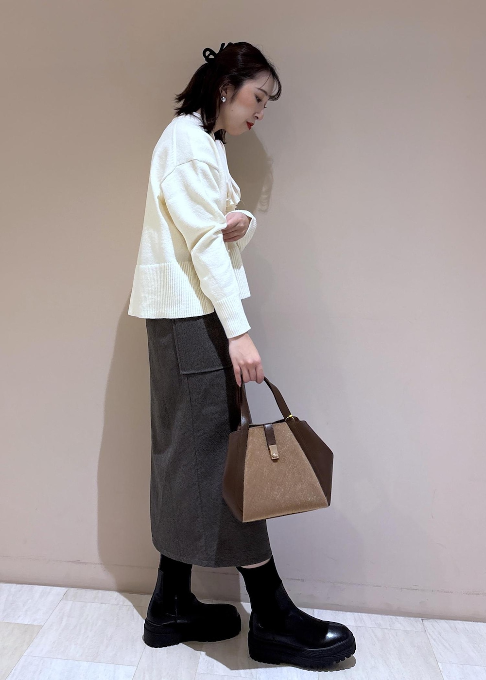 ホワイト系のニット/セーター、ホワイト系のシャツ/ブラウス、ブラウン系のトートバッグを着用したレディースの秋コーディネートの7枚目の写真