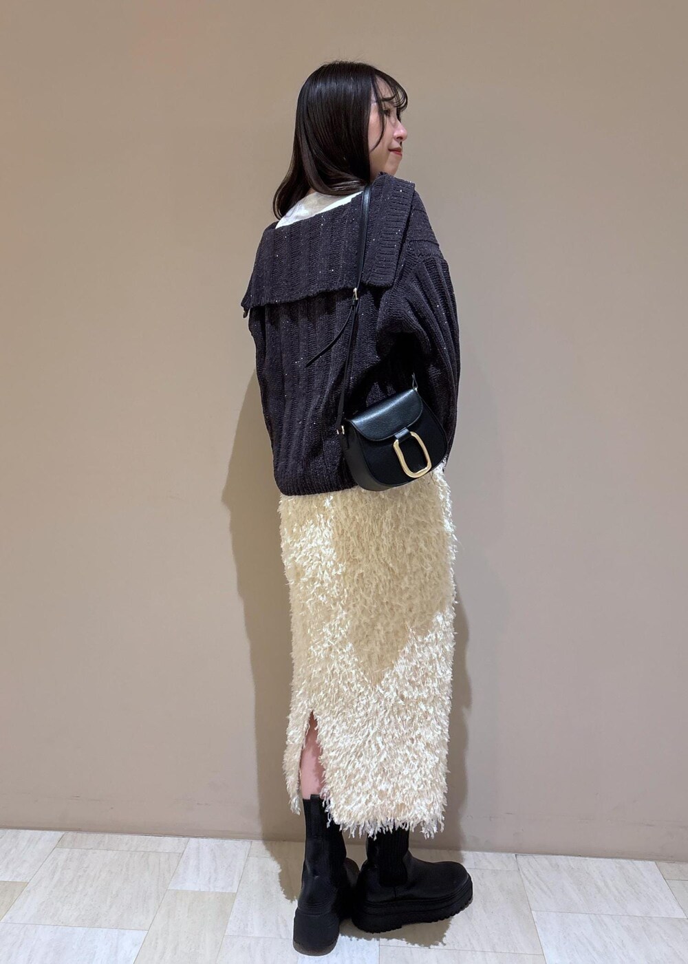 ホワイト系のスカート、ホワイト系のTシャツ/カットソー、グレー系のニット/セーターを着用したレディースの冬コーディネートの6枚目の写真