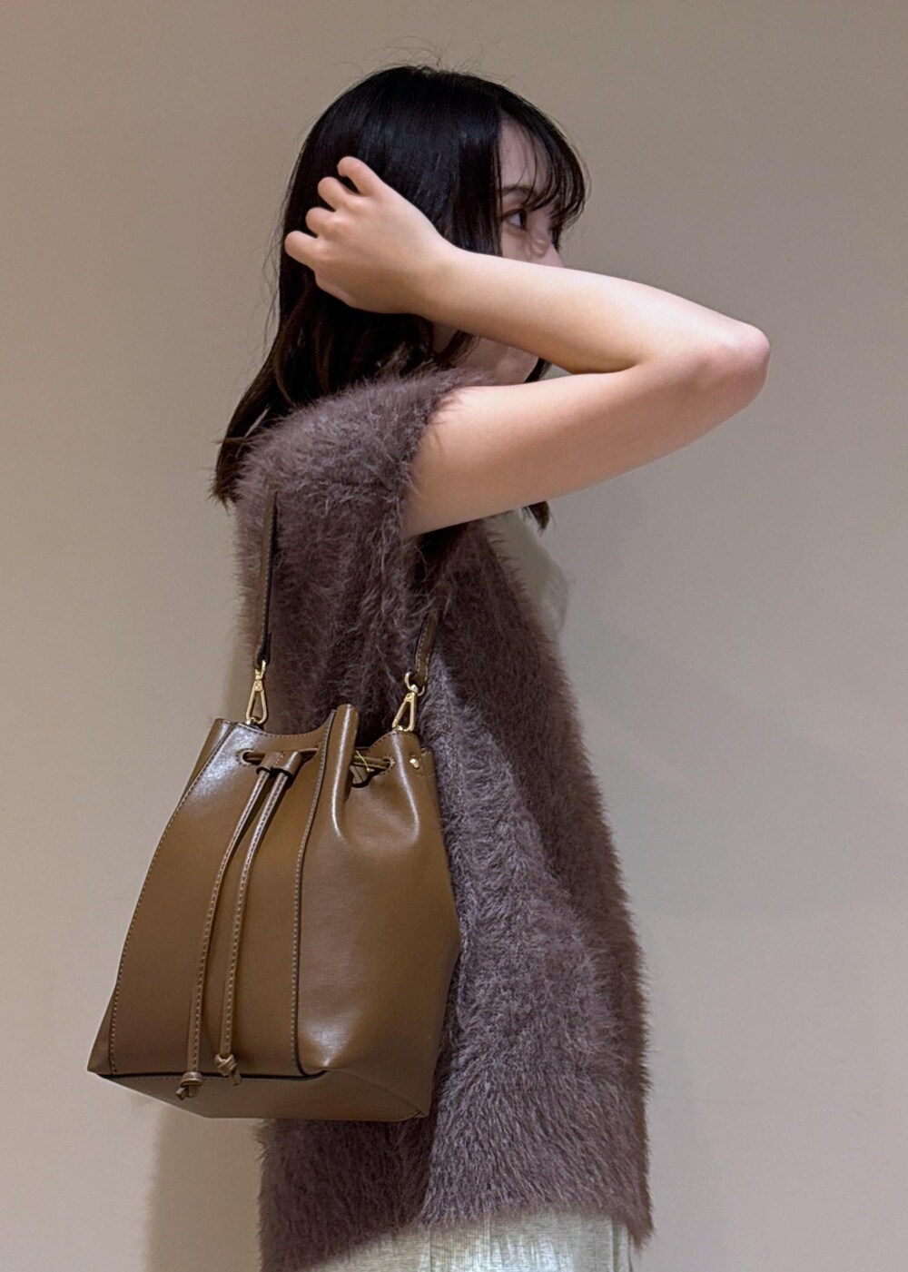 ブラウン系のショルダーバッグ、ブラウン系のベスト、グレー系のスカートを着用したレディースの夏コーディネートの7枚目の写真