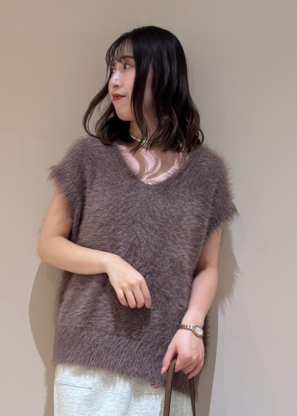 ブラウン系のショルダーバッグ、ブラウン系のベスト、グレー系のスカートを着用したレディースの夏コーディネートの6枚目の写真