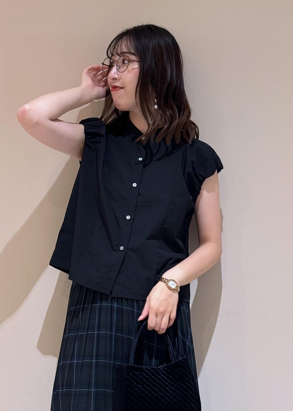 グリーン系のスカート、ブラック系のシャツ/ブラウス、シルバー系のローファーを着用したレディースの夏コーディネートの5枚目の写真