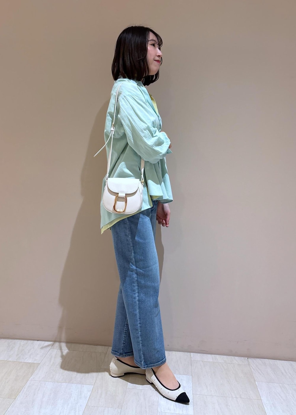 ホワイト系のショルダーバッグ、ブルー系のデニムパンツ、グリーン系のシャツ/ブラウスを着用したレディースの冬コーディネートの5枚目の写真