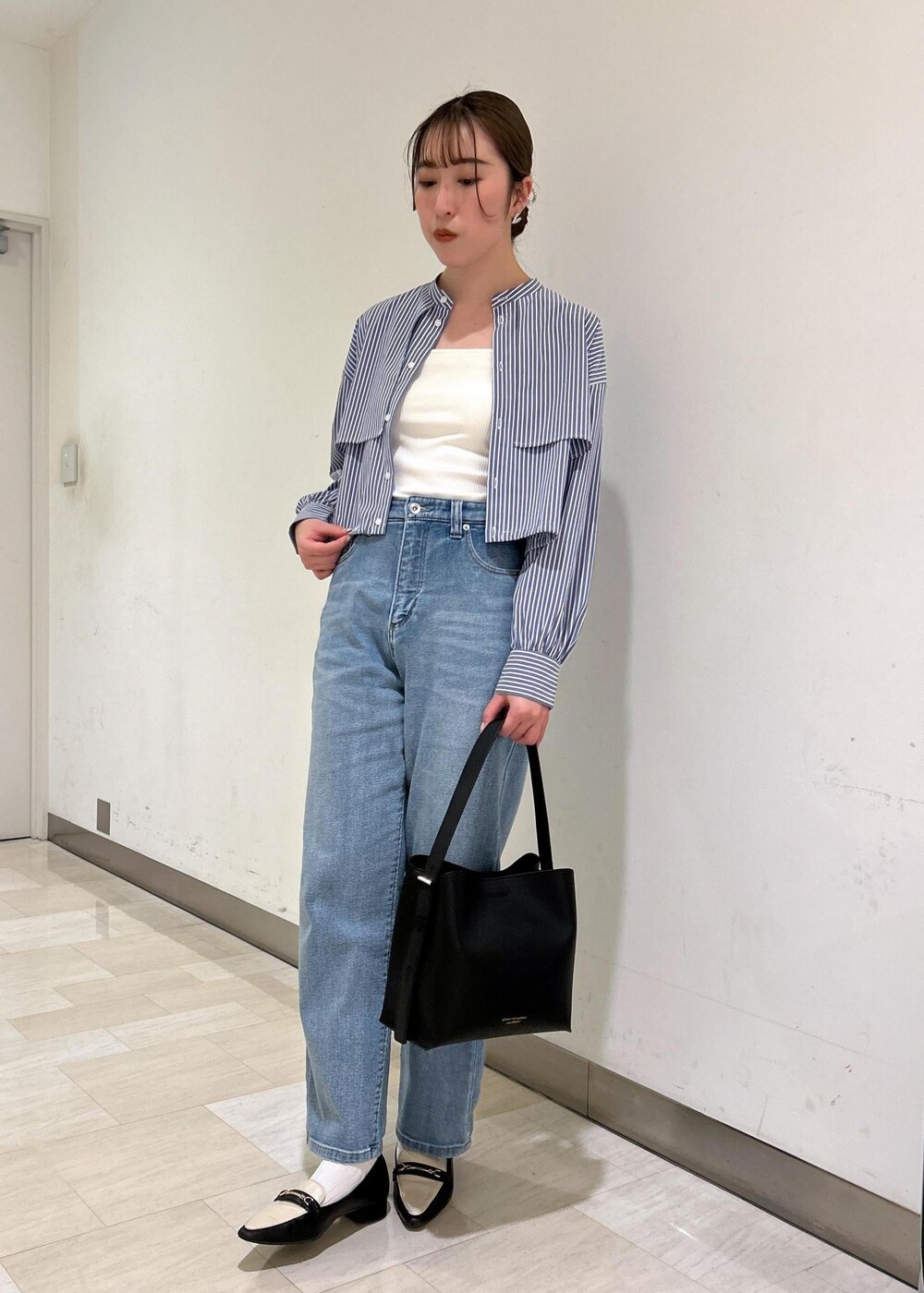 ブラック系のショルダーバッグ、ブルー系のシャツ/ブラウス、ブルー系のデニムパンツを着用したレディースの春コーディネートの4枚目の写真