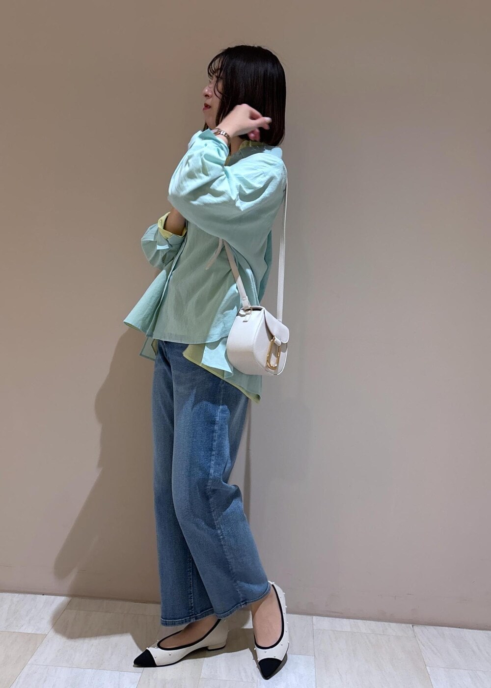 ホワイト系のショルダーバッグ、ブルー系のデニムパンツ、グリーン系のシャツ/ブラウスを着用したレディースの冬コーディネートの3枚目の写真