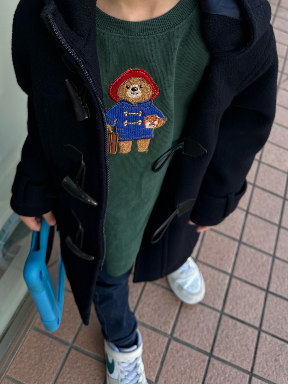 グリーン系のスウェット、ブルー系のダッフルコート、ブルー系のデニムパンツを着用したキッズの春コーディネートの2枚目の写真