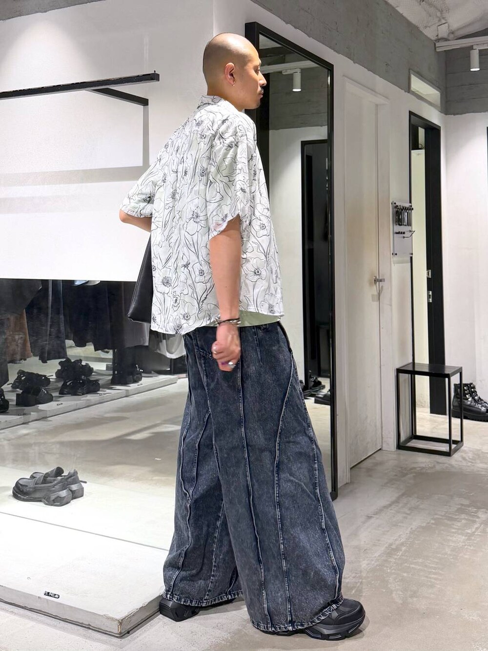 ブラック系のスニーカー、ブルー系のデニムパンツ、グリーン系のTシャツ/カットソーを着用したメンズの夏コーディネートの4枚目の写真