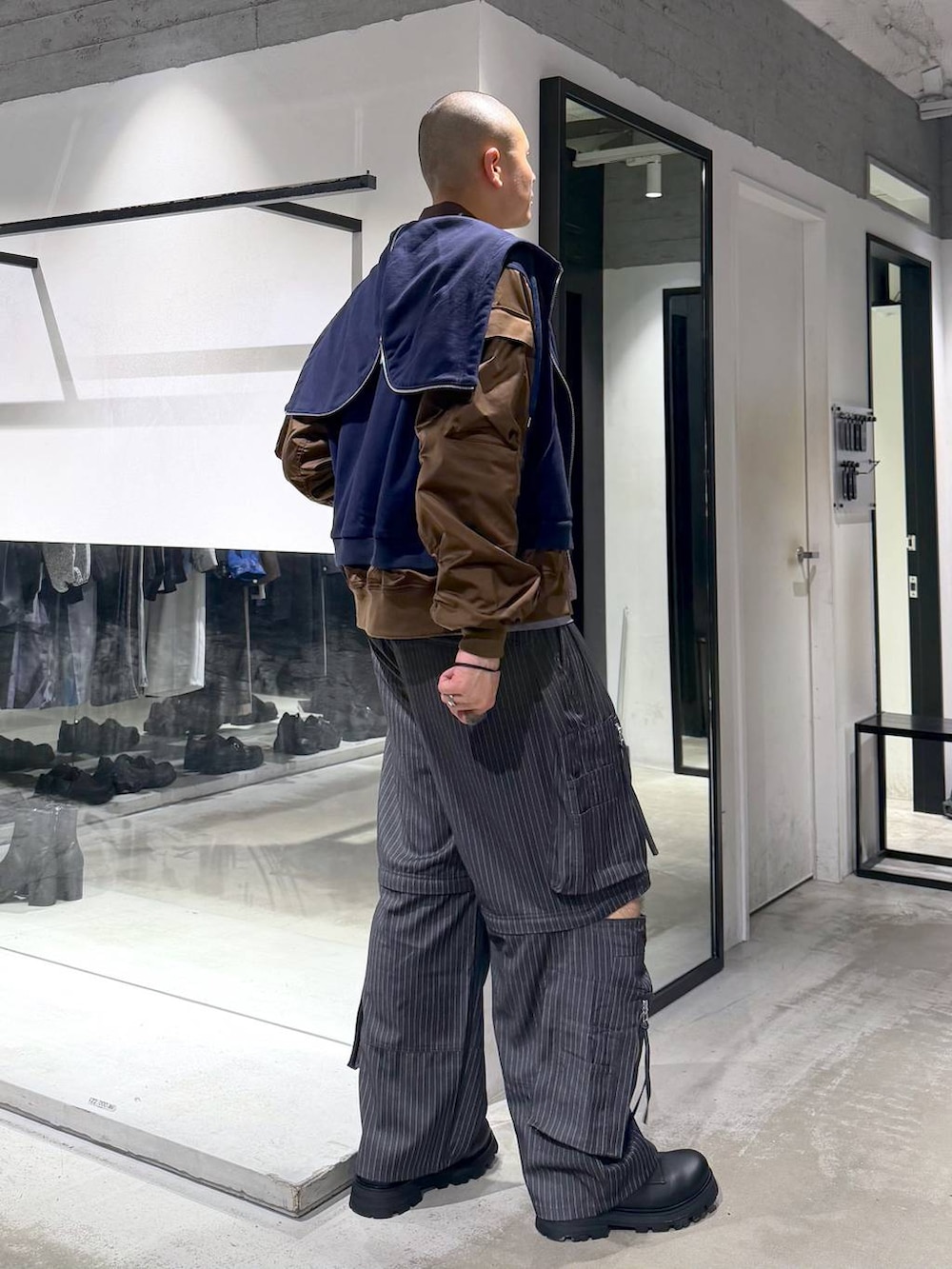 ブラック系のドレスシューズ、グレー系のカーゴパンツ、ブルー系のパーカーを着用したメンズの春コーディネートの4枚目の写真