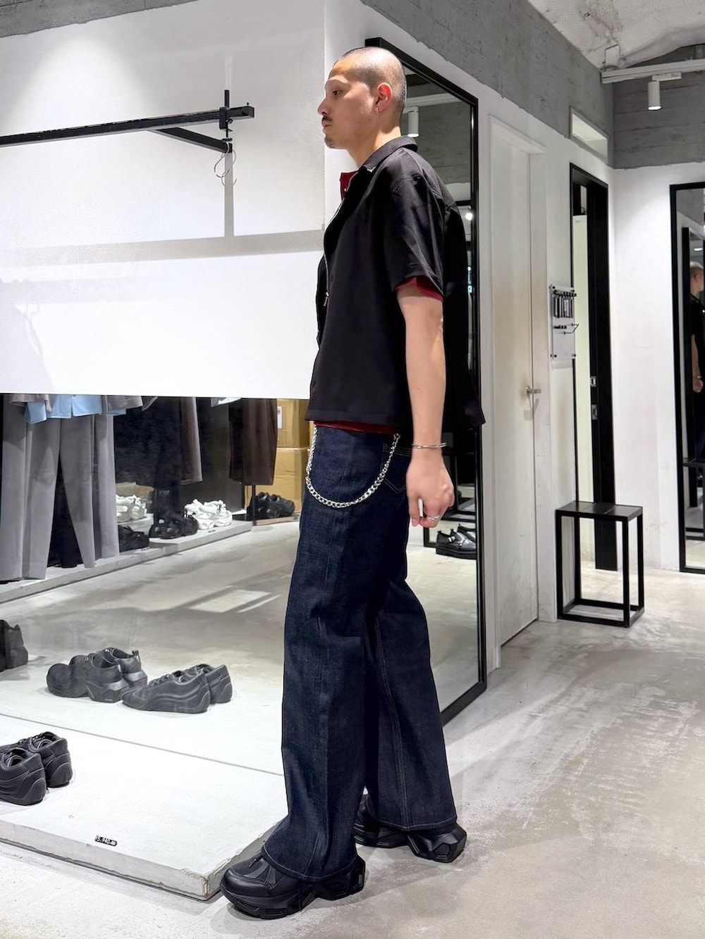 ブラック系のスニーカー、レッド系のTシャツ/カットソー、ブルー系のデニムパンツを着用したメンズの夏コーディネートの3枚目の写真