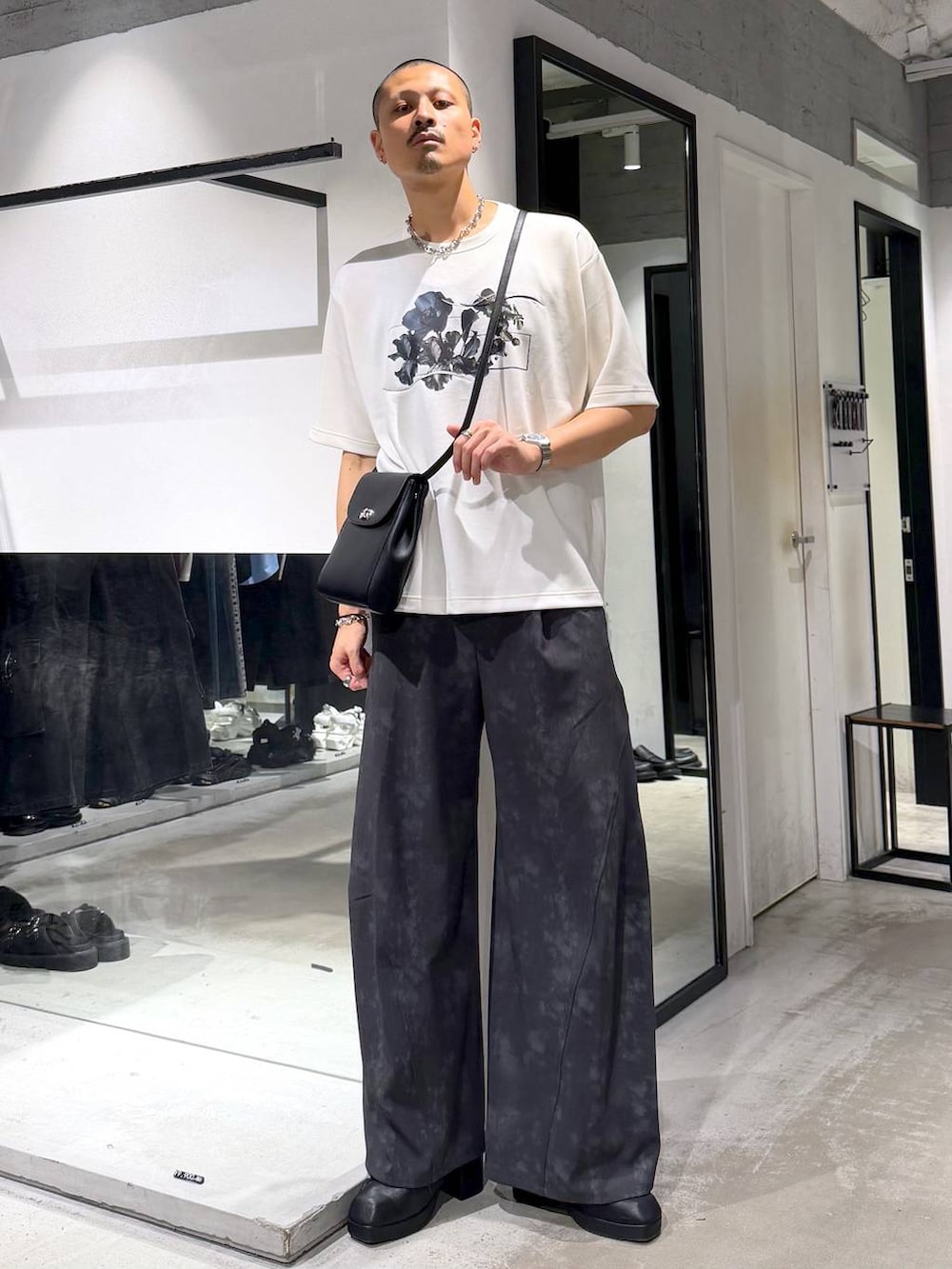 ブラック系のショルダーバッグ、ブラック系のサンダル、グレー系のスラックスを着用したメンズの夏コーディネートの5枚目の写真