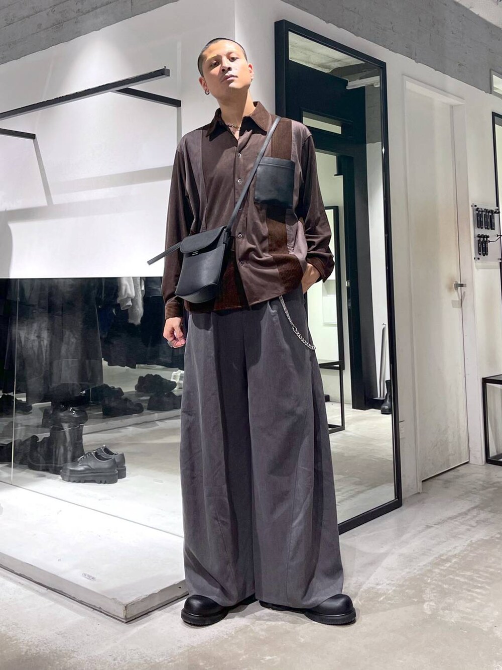 ブラック系のダウンジャケット/コート、グレー系のスラックス、ブラック系のドレスシューズを着用したメンズの冬コーディネートの6枚目の写真