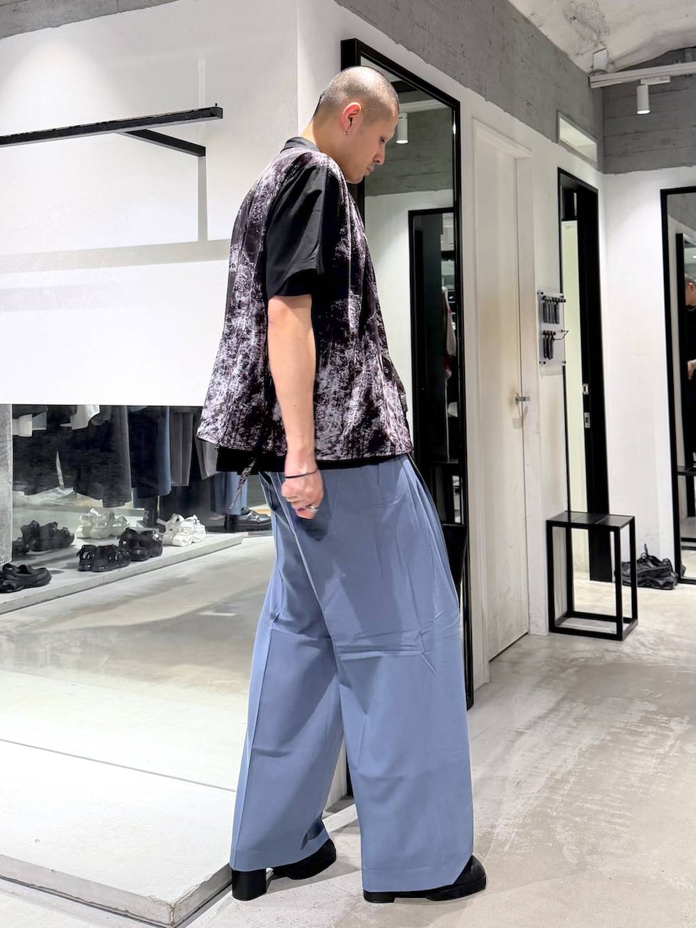 ブラック系のTシャツ/カットソー、ブラック系のサンダル、ブルー系のスラックスを着用したメンズの春コーディネートの4枚目の写真
