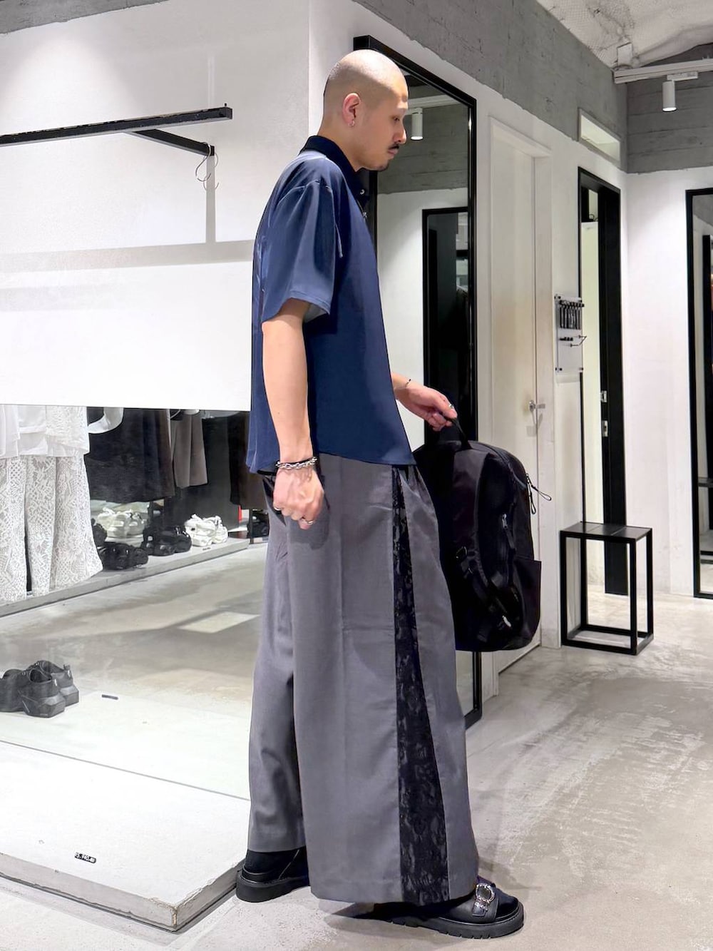 グレー系のその他パンツ、ブラック系のバックパック/リュック、ブラック系のサンダルを着用したメンズの夏コーディネートの4枚目の写真