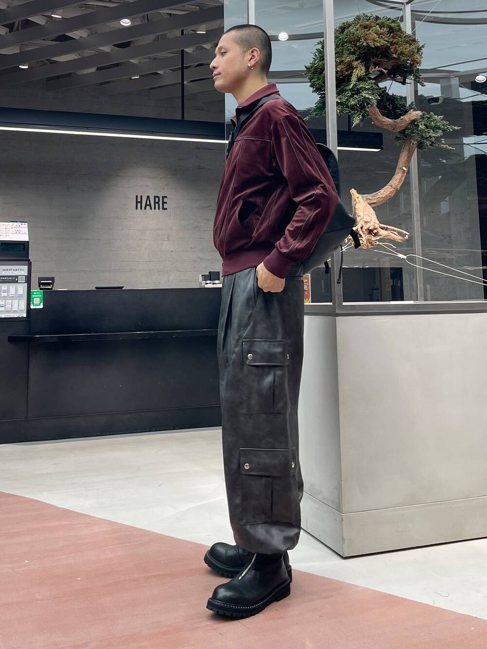 グレー系のカーゴパンツ、ブラック系のメッセンジャーバッグ、ブラック系のブーツを着用したメンズの秋コーディネートの2枚目の写真